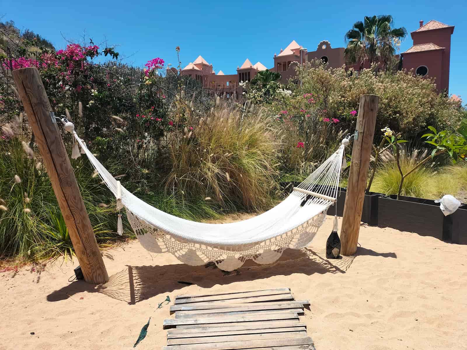 Padded quilted hammock with wooden spreader bars in a garden