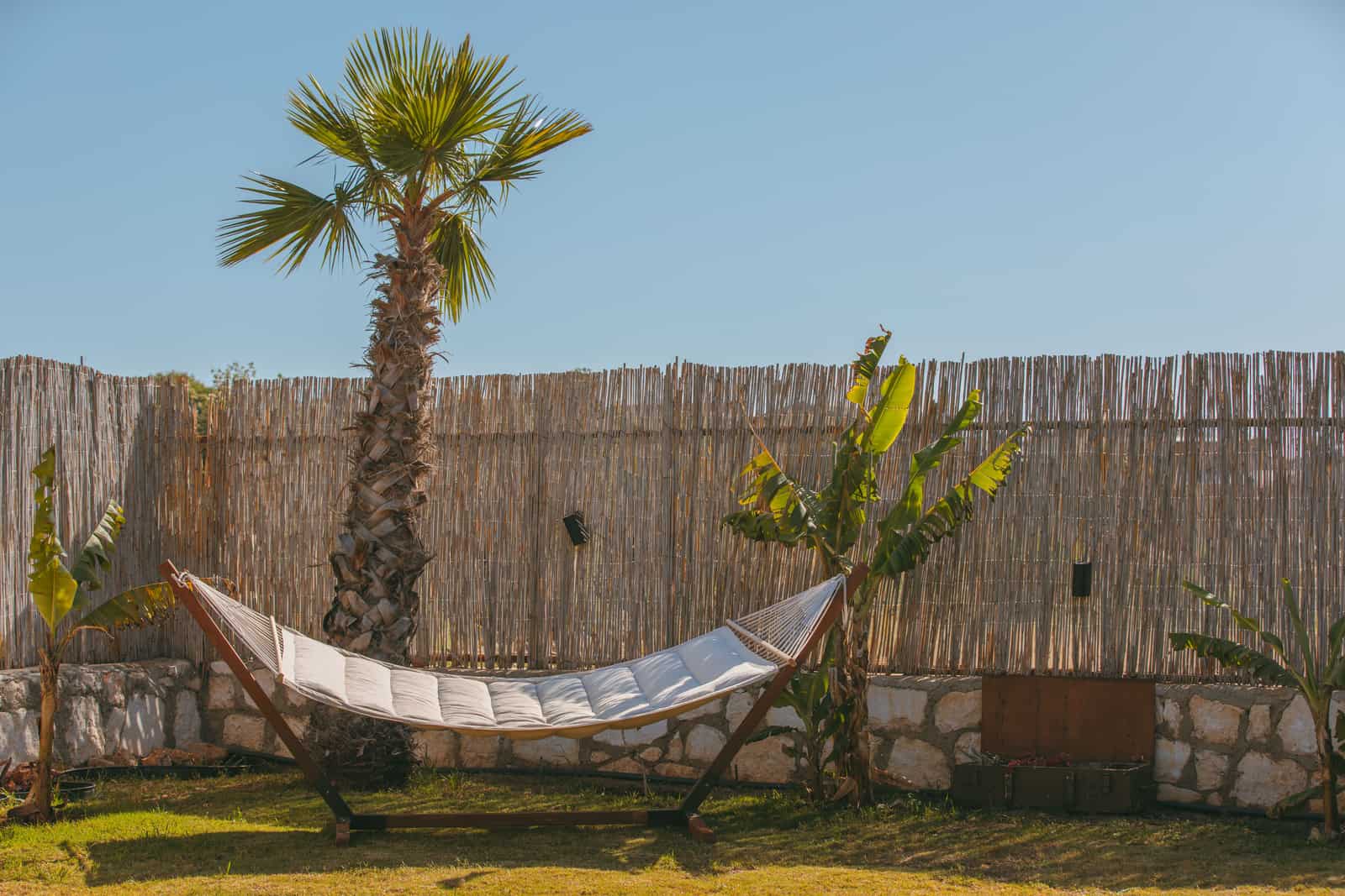 Curved wooden hammock stand standing on a lawn